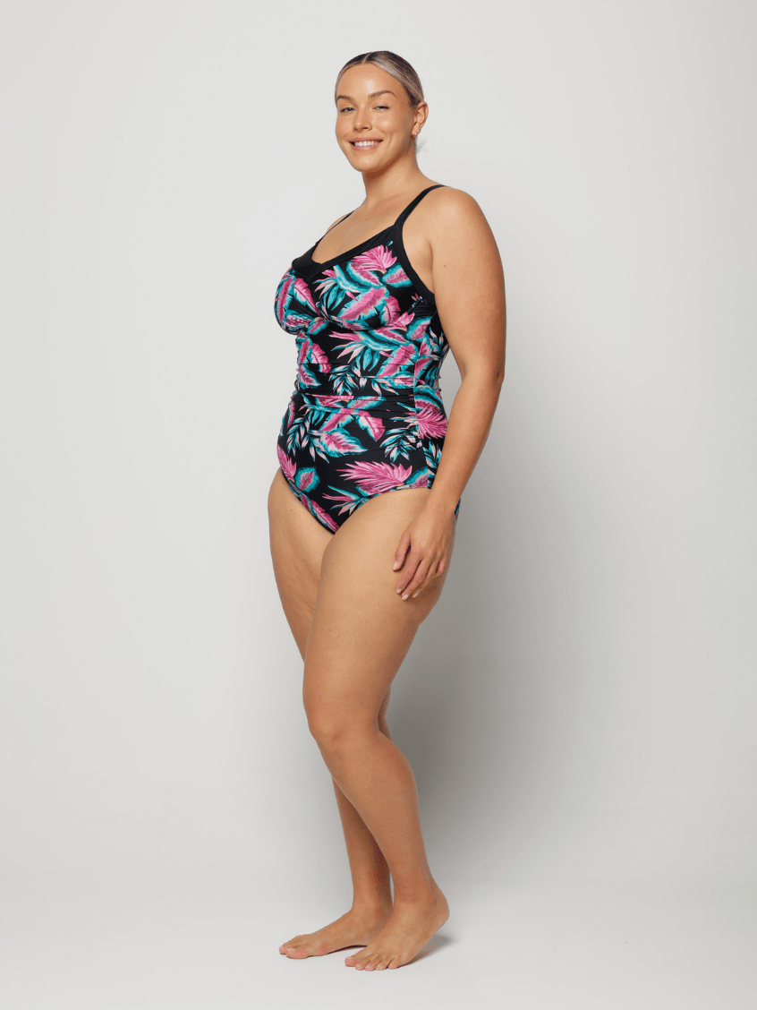 Woman wearing a tropical floral swimsuit on a white background