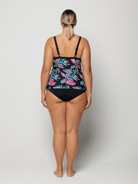 Woman wearing a black swimsuit with pink floral pattern on a white background