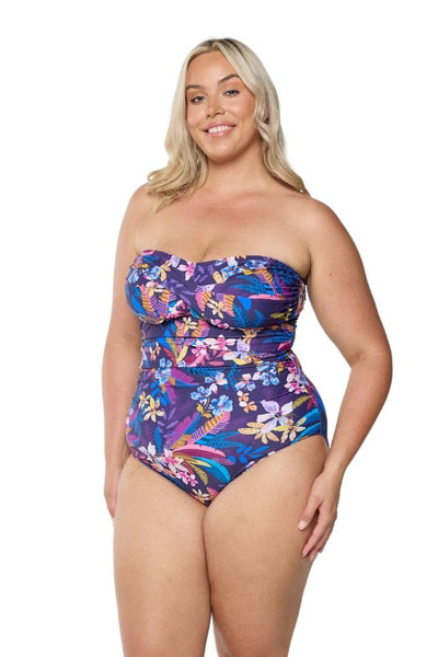 Blonde model in studio wearing plus size one piece with removable straps in navy based floral print