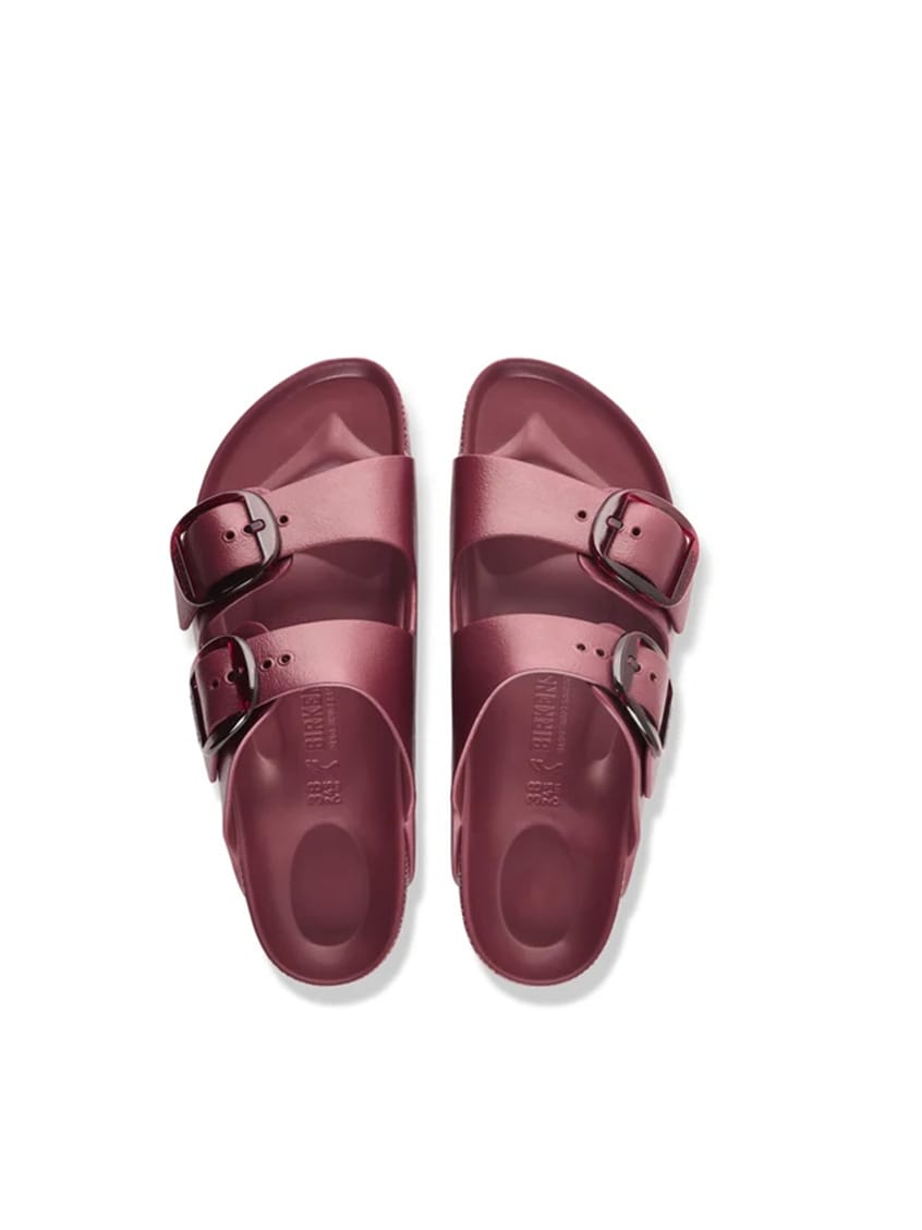 A pair of deep burgundy double-strap slide sandals with silver buckle details, shown from a top-down view on a white background.