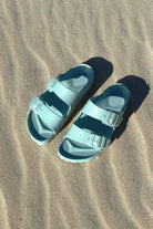 Light teal sandals on beach