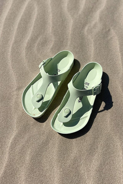 Lime green birkenstock sandals on beach for plus size women
