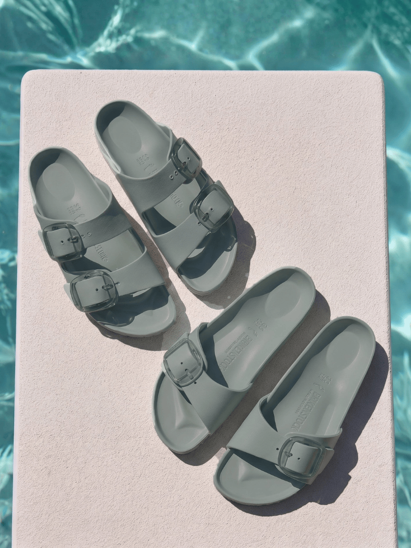Group image of two beach birkenstock sandals in sage by the pool