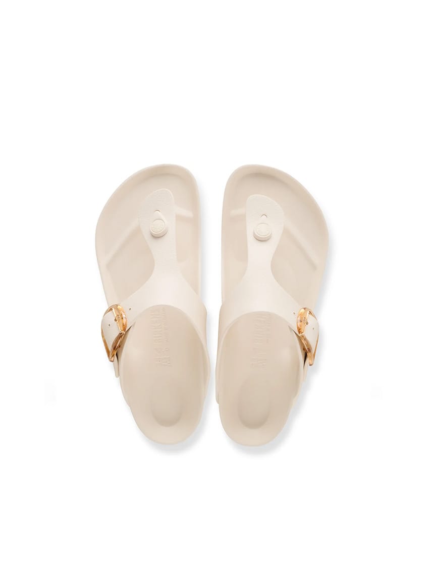 A pair of Birkenstock Florida slide sandals in a light cream color with gold-tone buckle straps, shown from a top-down view on a white background.