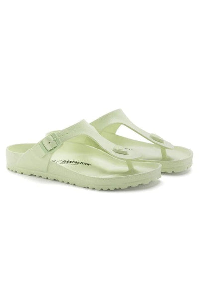 side profile of faded lime T style sandals with side buckle