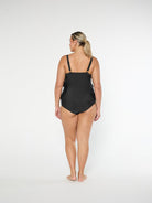 Woman wearing a black swimsuit on a white background