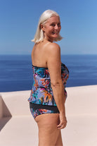 Side profile of model wearing flattering high waisted belly pant with tropical print for curve women