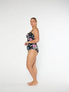 Woman wearing a floral high-waisted swimsuit on a white background