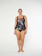 Woman wearing a black floral swimsuit on a white background