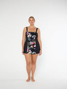 Woman wearing a black floral swimsuit on a white background