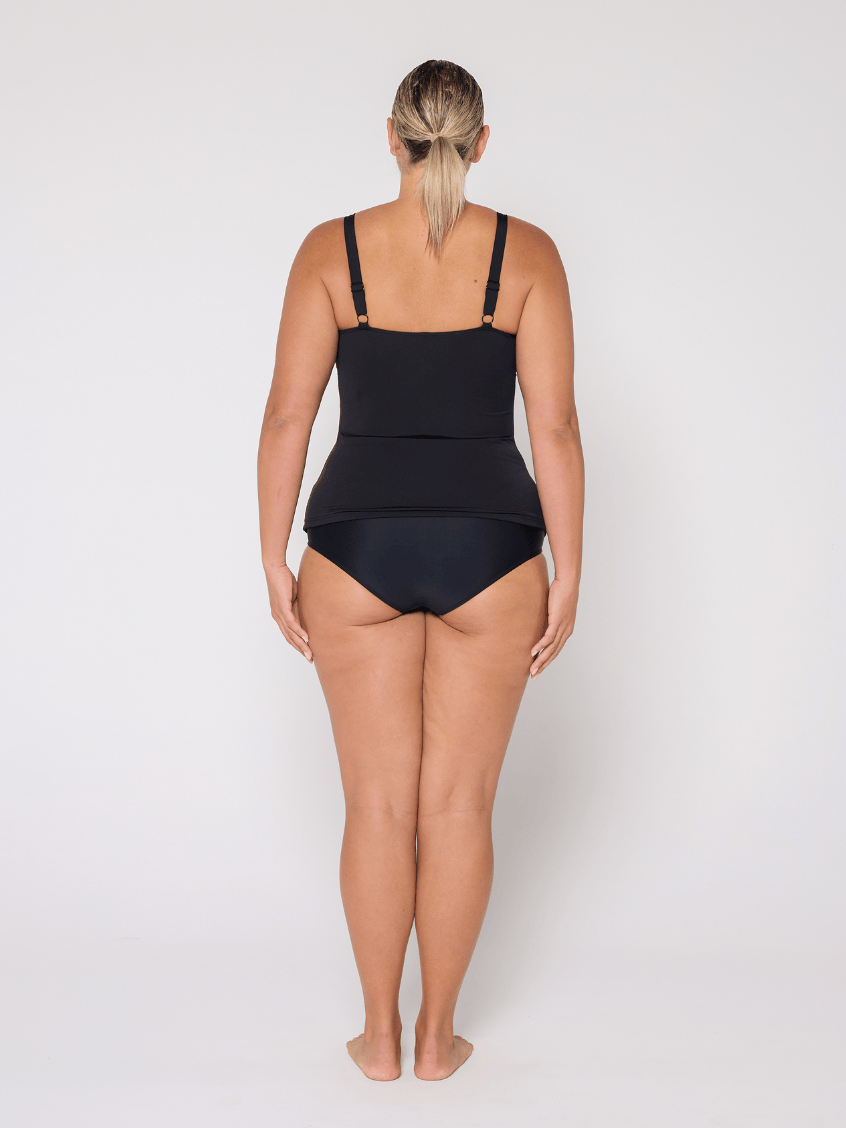 Side profile of woman in studio wearing a high neck tankini top with adjustable straps
