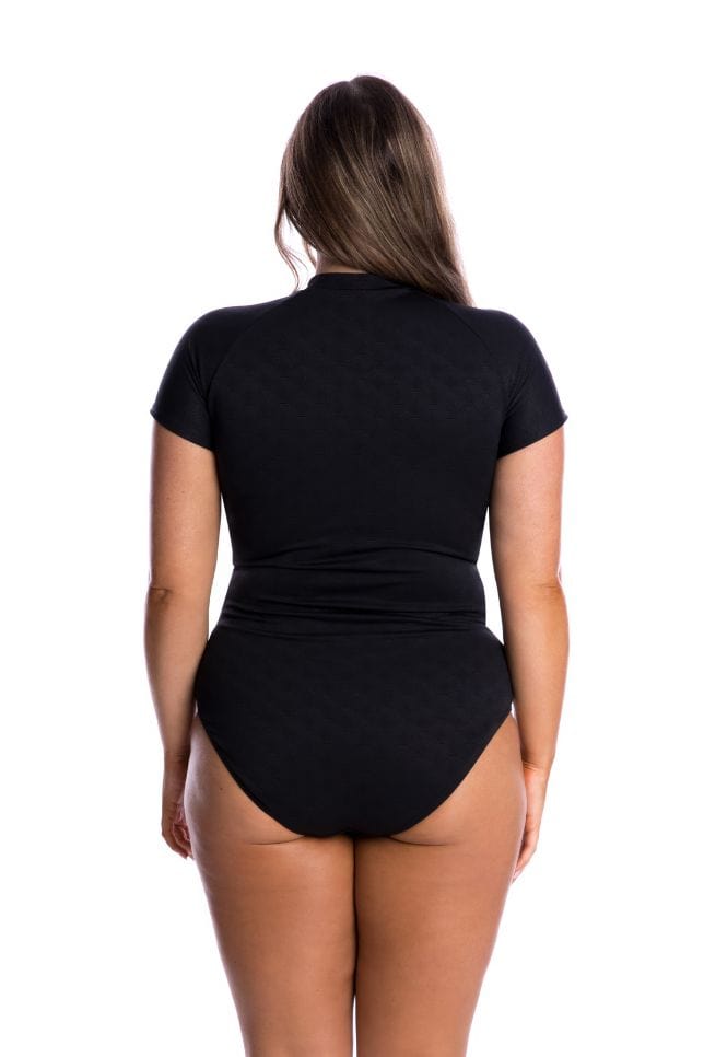 Back of brunette plus size model wearing black and white textured cap sleeve one piece