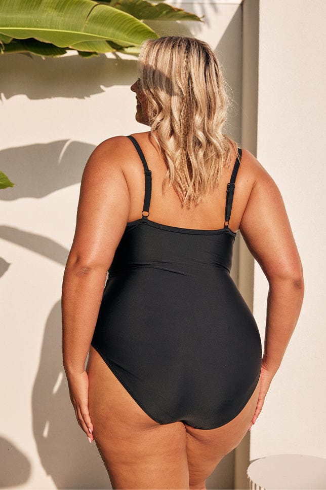 Blonde model showing back of black womens one piece