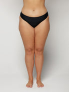 Person wearing black underwear on a plain background
