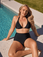 Blonde woman by pool wearing high waisted pant bottom for curve women