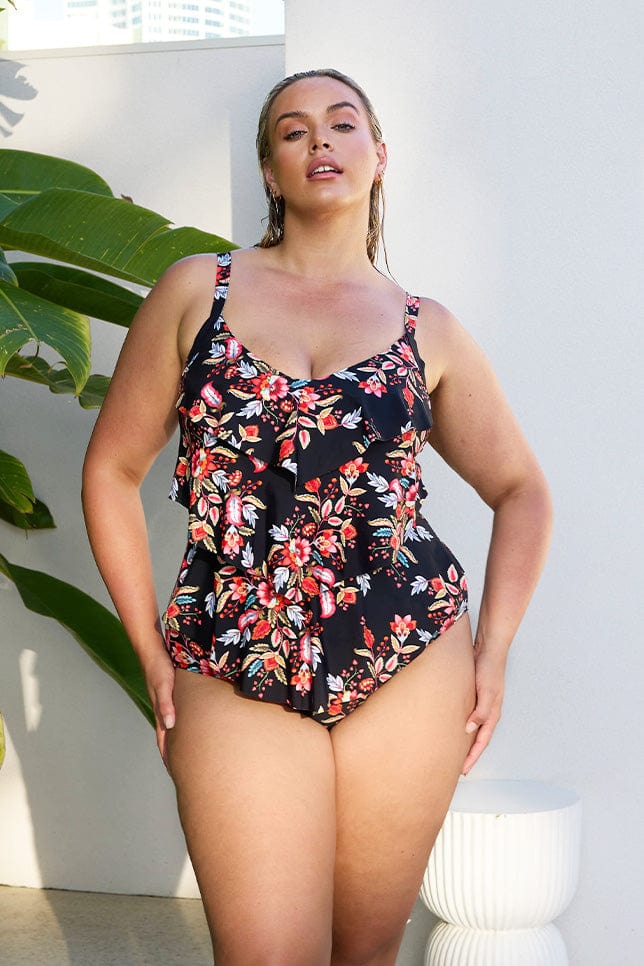 Blonde curve model wearing 3 tiered ruffle one piece with floral berry coloured print