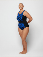 Person wearing a black and blue patterned swimsuit on a white background