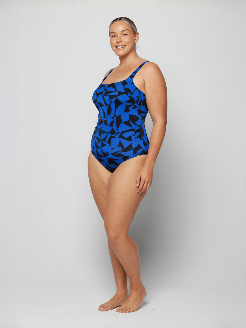 Woman wearing a blue patterned chlorine resistant swimsuit on a white background