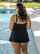 Woman wearing a black swim dress in blue and black floral print