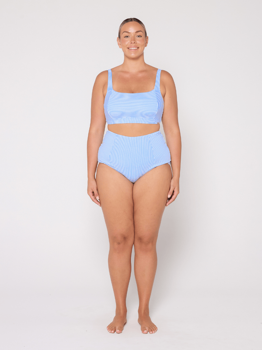 Woman wearing a light blue bikini set on a white background