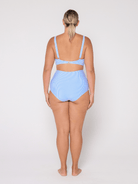 Woman wearing a light blue bikini set on a white background