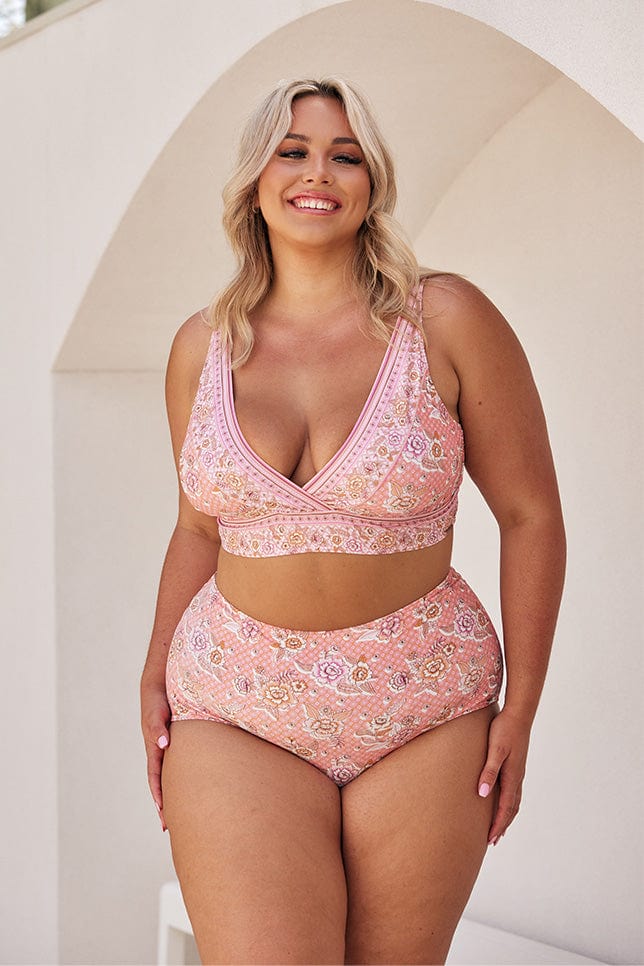 Blonde model wearing pink floral v neck bikini with high waisted pants