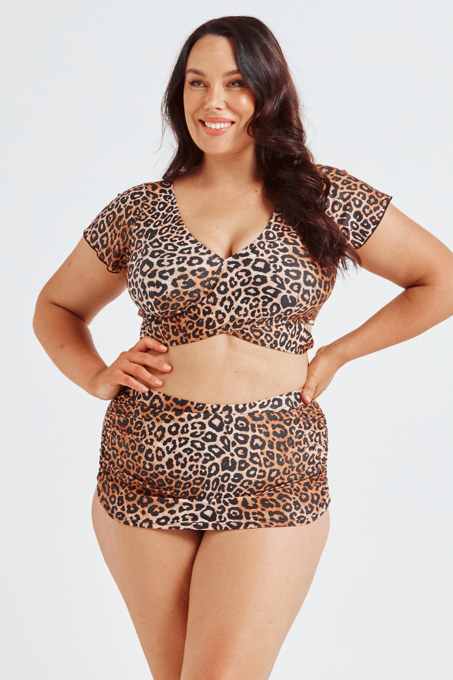 Woman wearing a leopard print two-piece swimsuit on a white background