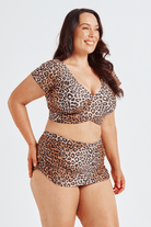 Woman wearing a leopard print bikini set on a white background