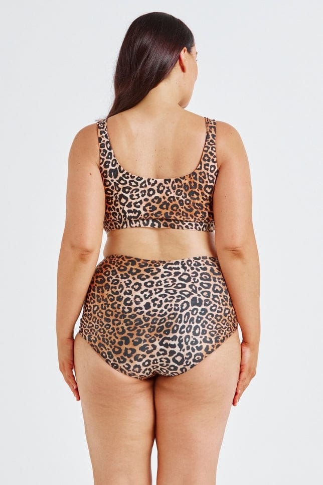 Person wearing a leopard print bikini set on a white background