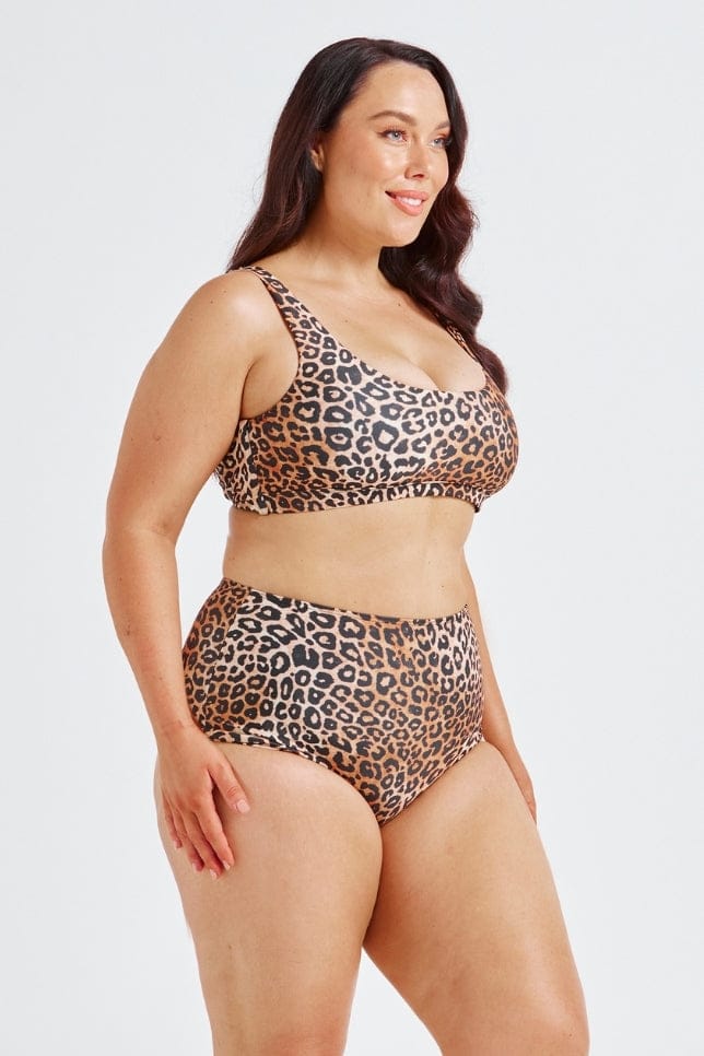 Woman wearing a leopard print swimsuit on a white background
