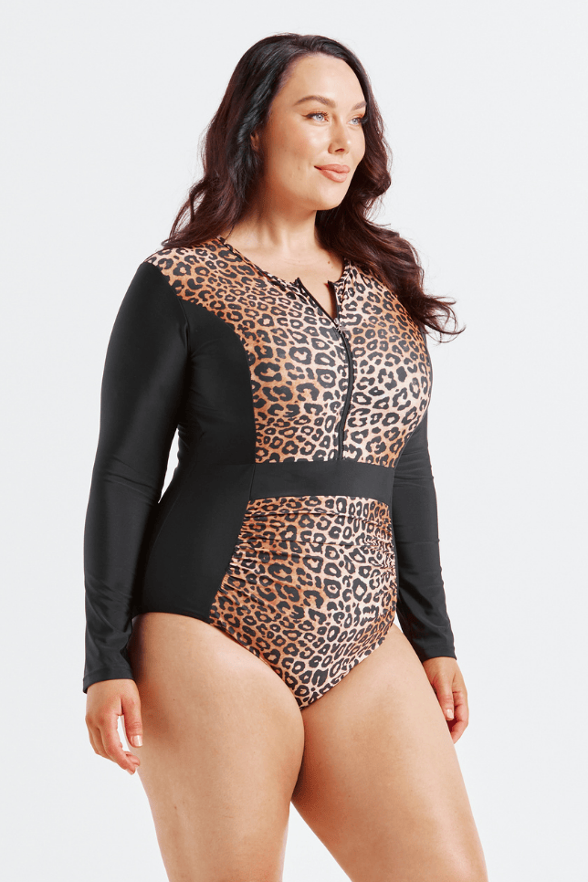 Woman wearing a leopard print swimsuit with black sleeves on a white background
