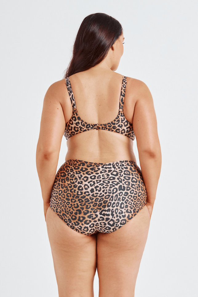 Woman wearing a leopard print bikini on a white background