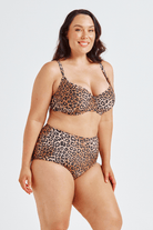 Woman wearing a leopard print bikini on a white background