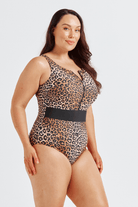 Woman wearing a leopard print swimsuit with a black belt on a white background