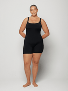 Person wearing a black boyleg one piece in chlorine resistant against a white background