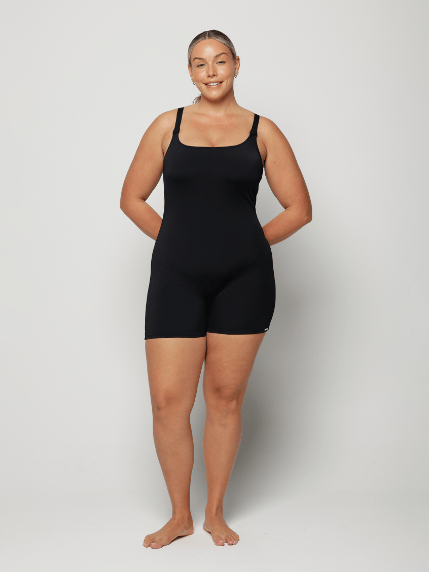 Person wearing a black boyleg one piece in chlorine resistant against a white background