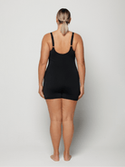 Person wearing a black boyleg one peice on a white background