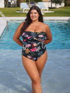 Woman in a floral swimsuit standing by a pool with greenery in the background