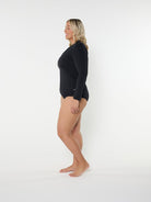 Woman wearing a black bodysuit on a white background