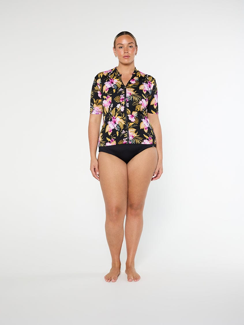 Woman wearing a floral short-sleeve swimsuit on a white background