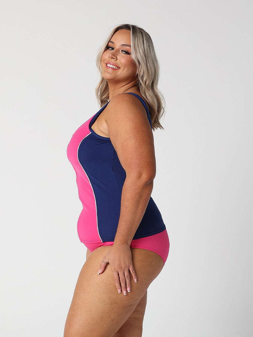 Side profile of blonde model in studio wearing navy and pink tankini top for curvy woman
