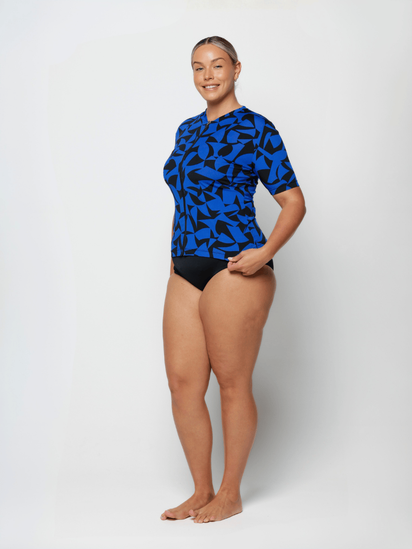 Person wearing a blue and black patterned swimsuit on a white background