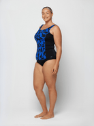 Woman wearing a black and blue patterned swimsuit on a white background