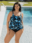 Woman wearing a black and blue floral swimsuit by a pool