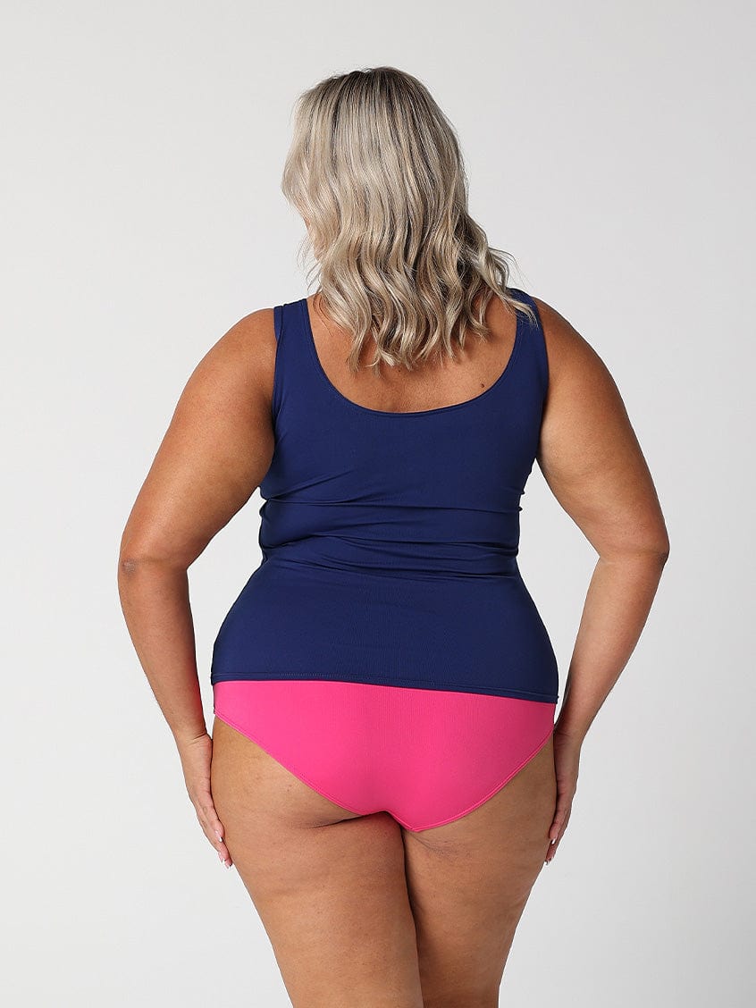 Back of model in studio showing off navy and pink chlorine resistant zip front tankini
