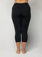 Woman wearing black leggings on a plain background