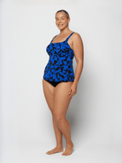 Woman wearing a blue patterned swimsuit on a white background