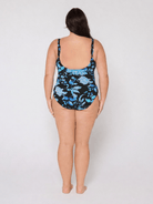 Woman wearing a blue and black floral swimsuit with scoop back
