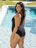 Woman in a blue and black swimsuit with high back standing in a pool