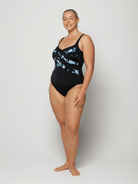 Woman wearing a black swimsuit with blue floral pattern on a white background